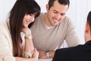 Two professionals reviewing documents at laptop
