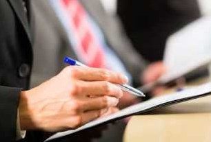 Hand signing legal document with pen